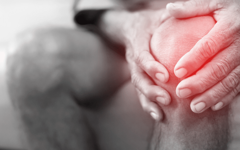 close up of hands clutching at inflamed knee